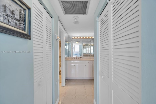 hallway featuring sink and light tile patterned floors