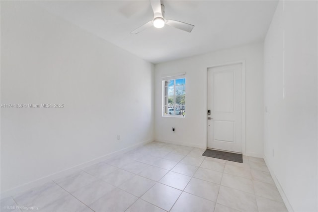 tiled spare room featuring ceiling fan