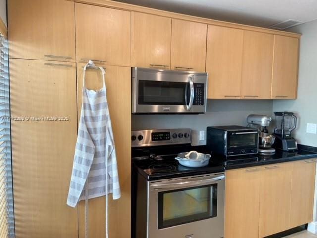 kitchen featuring light brown cabinets and appliances with stainless steel finishes