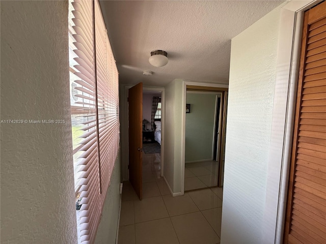 11277 SW 172nd St Unit I1742D, Miami, FL 33157 - corridor featuring a textured ceiling, tile patterned floors, and a textured wall