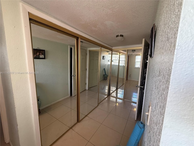 11277 SW 172nd St Unit I1742D, Miami, FL 33157 - hall featuring a textured ceiling, light tile patterned floors, and a textured wall