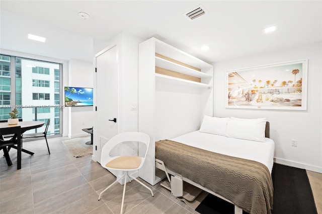 bedroom with expansive windows and light tile patterned floors