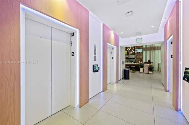 corridor with elevator and light tile patterned floors