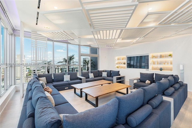 living room with a wall of windows and light hardwood / wood-style flooring