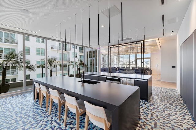 kitchen with expansive windows and an island with sink