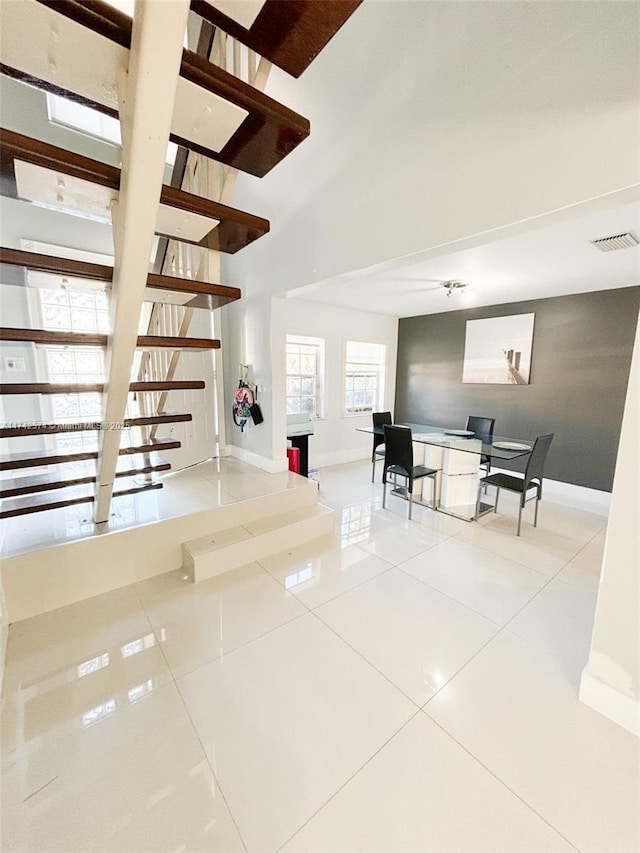 staircase featuring tile patterned flooring and a high ceiling