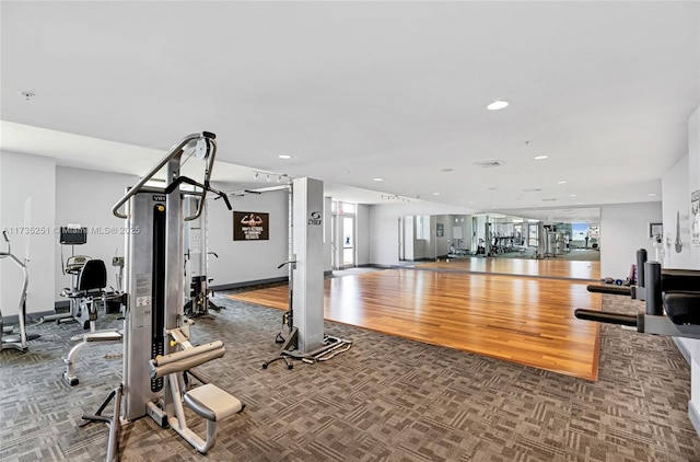 workout area with carpet floors, recessed lighting, plenty of natural light, and wood finished floors