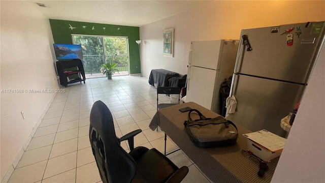 interior space featuring light tile patterned floors, stainless steel refrigerator, and white refrigerator