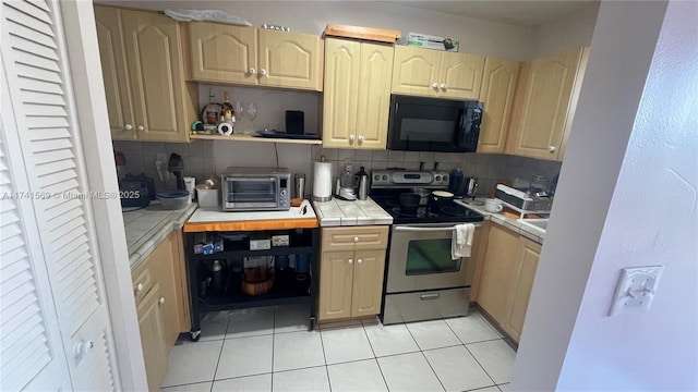 kitchen featuring light tile patterned flooring, stainless steel electric range oven, light brown cabinets, tile counters, and decorative backsplash