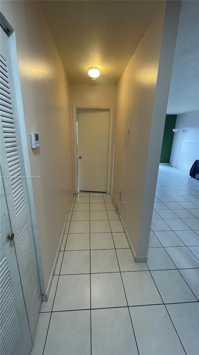 hallway featuring light tile patterned flooring and a textured ceiling