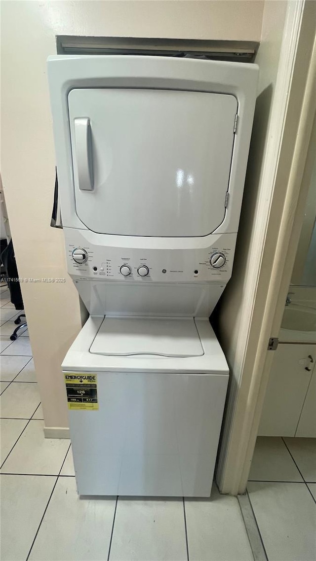 washroom featuring stacked washer / dryer and light tile patterned flooring