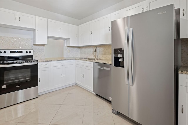 kitchen featuring stainless steel appliances, light stone countertops, and white cabinets