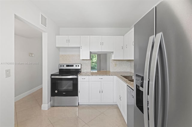 kitchen with light stone counters, stainless steel appliances, and white cabinets