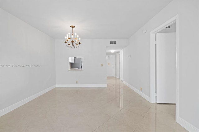 unfurnished room featuring a notable chandelier