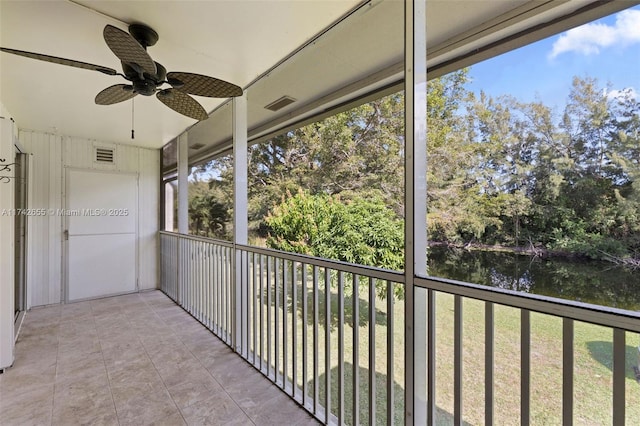 balcony with ceiling fan and a water view