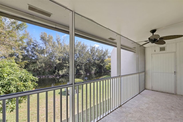 unfurnished sunroom with a water view and ceiling fan