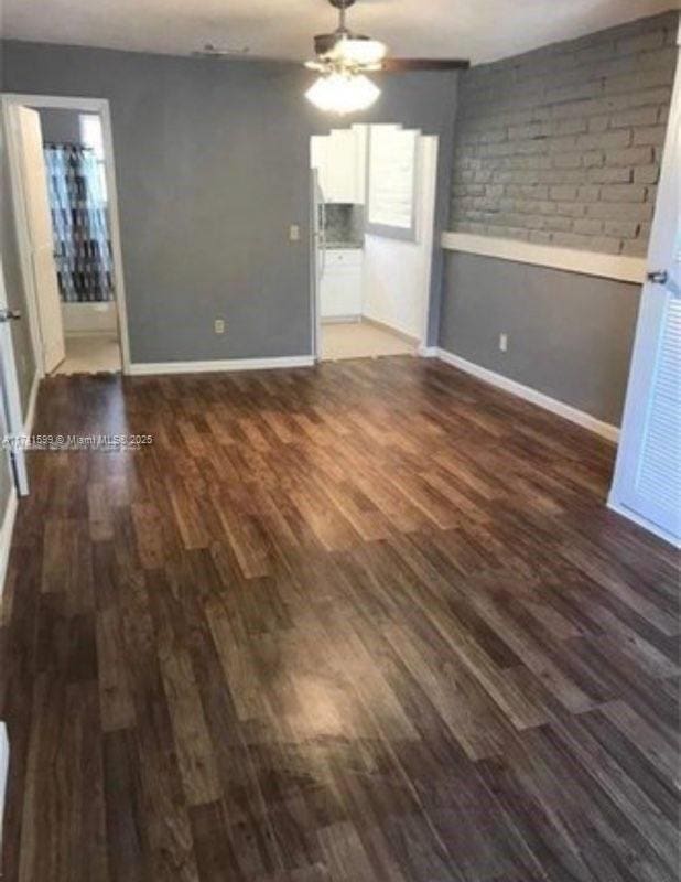 interior space featuring dark wood-type flooring and ceiling fan