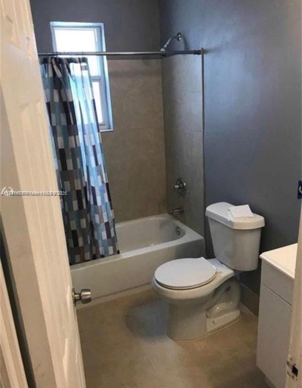 full bathroom with shower / tub combo with curtain, vanity, toilet, and tile patterned flooring