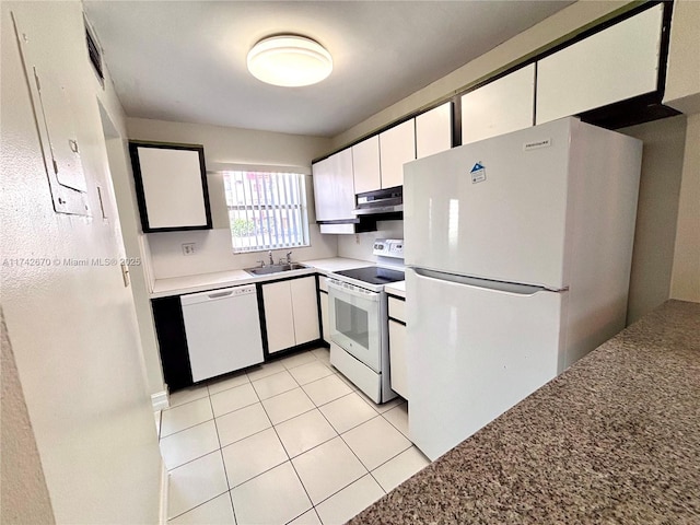 kitchen with white cabinetry, sink, white appliances, and light tile patterned flooring