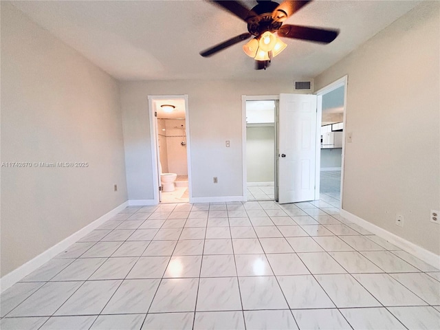 unfurnished bedroom with ceiling fan, a walk in closet, connected bathroom, and light tile patterned flooring