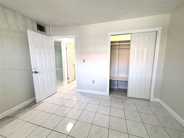 unfurnished bedroom featuring a closet and a textured ceiling