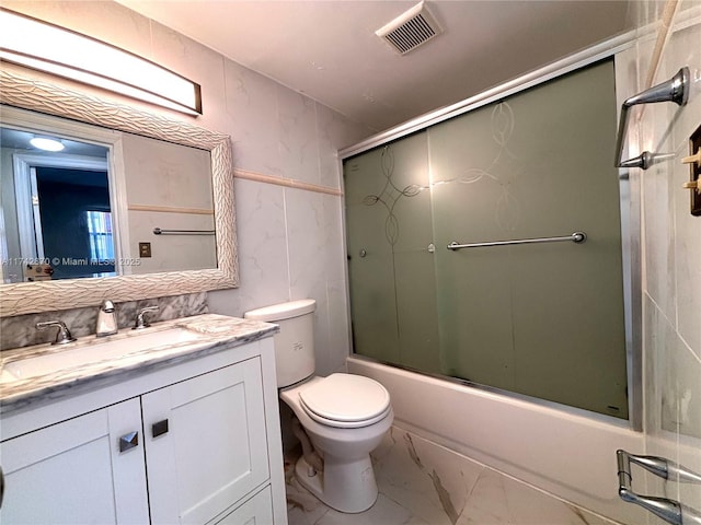 full bathroom featuring enclosed tub / shower combo, vanity, and toilet