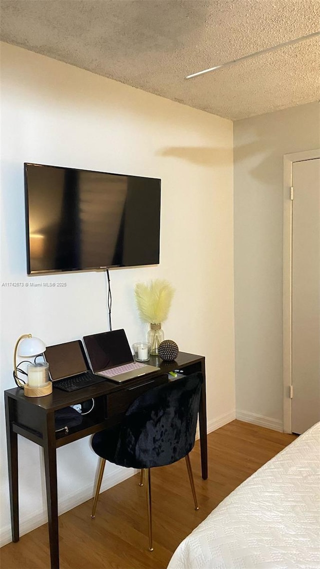 bedroom featuring wood-type flooring and a textured ceiling