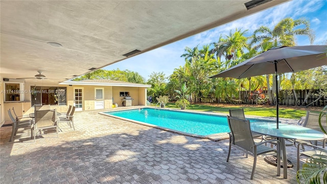 view of swimming pool featuring ceiling fan, a grill, and a patio