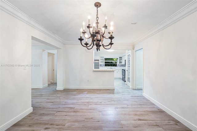 unfurnished dining area featuring an inviting chandelier, crown molding, and light wood-type flooring