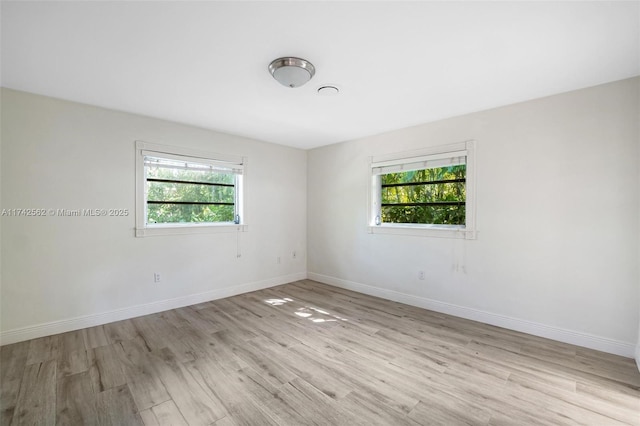 spare room featuring plenty of natural light and light hardwood / wood-style flooring