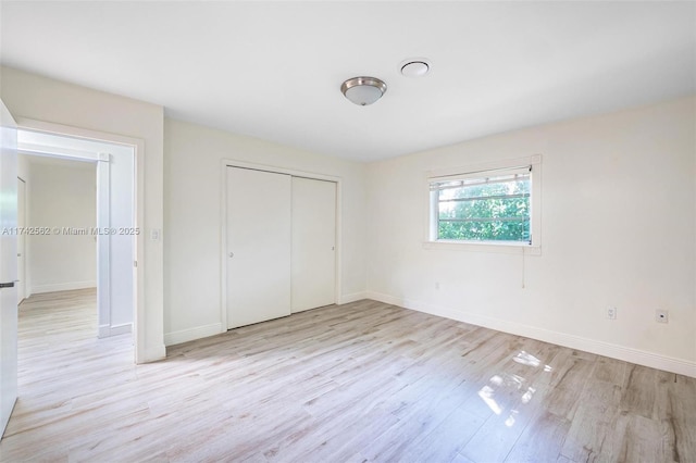 unfurnished bedroom featuring light hardwood / wood-style floors and a closet