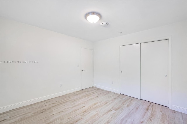 unfurnished bedroom featuring light hardwood / wood-style floors and a closet