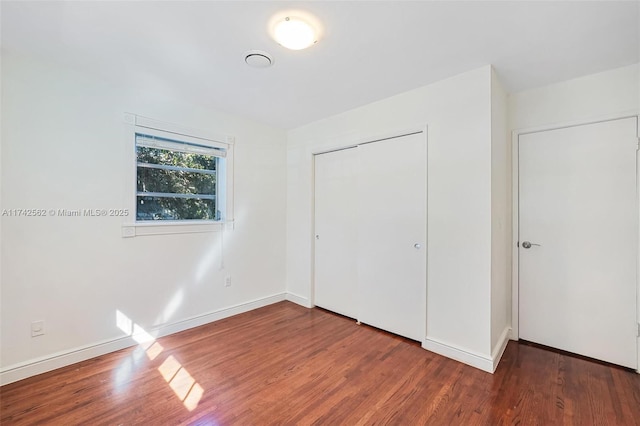 unfurnished bedroom with hardwood / wood-style floors and a closet