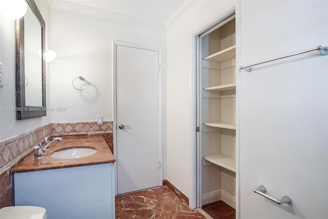 bathroom featuring crown molding, vanity, toilet, and built in features