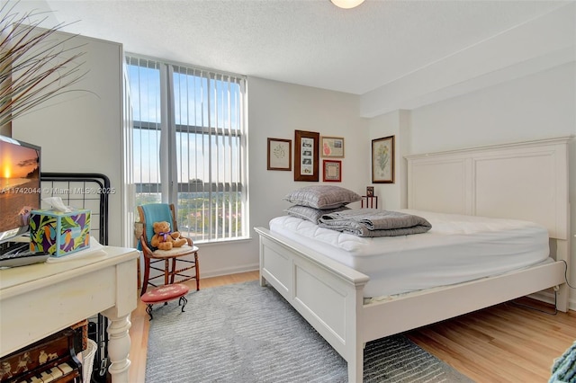 bedroom with wood-type flooring and a textured ceiling