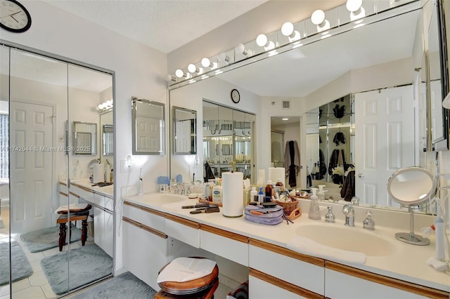 bathroom with vanity, tile patterned flooring, and a textured ceiling