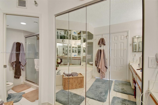 bathroom featuring vanity, tile patterned flooring, shower with separate bathtub, and a textured ceiling