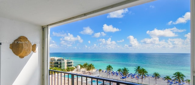 balcony featuring a water view and a view of the beach