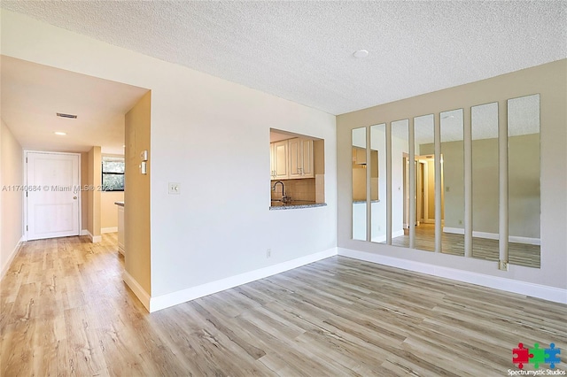 1036 US Highway 1 Unit 216, North Palm Beach, FL 33408 - spare room with light wood-type flooring, visible vents, baseboards, and a textured ceiling