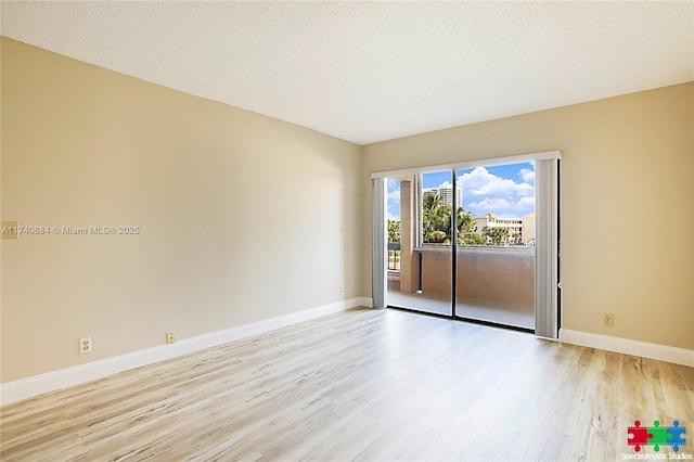 1036 US Highway 1 Unit 216, North Palm Beach, FL 33408 - unfurnished room featuring a textured ceiling, light wood-type flooring, and baseboards