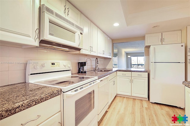 1036 US Highway 1 Unit 216, North Palm Beach, FL 33408 - kitchen with white appliances, a sink, white cabinetry, light wood-type flooring, and tasteful backsplash