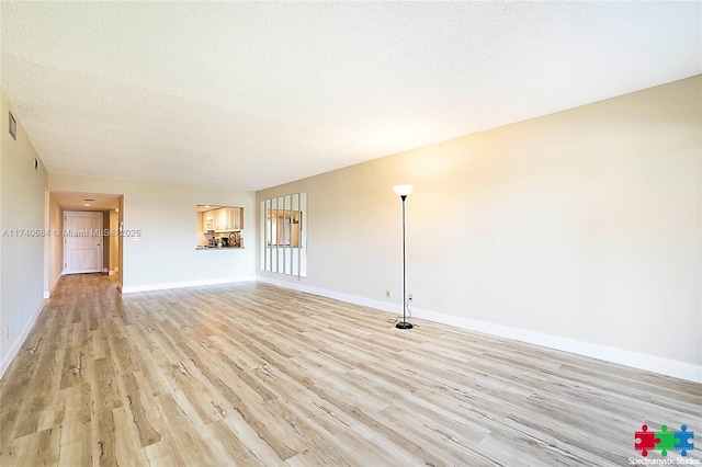 1036 US Highway 1 Unit 216, North Palm Beach, FL 33408 - unfurnished living room featuring a textured ceiling, light wood-type flooring, visible vents, and baseboards
