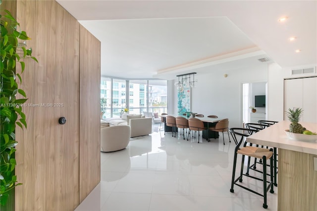 tiled living room featuring a wall of windows