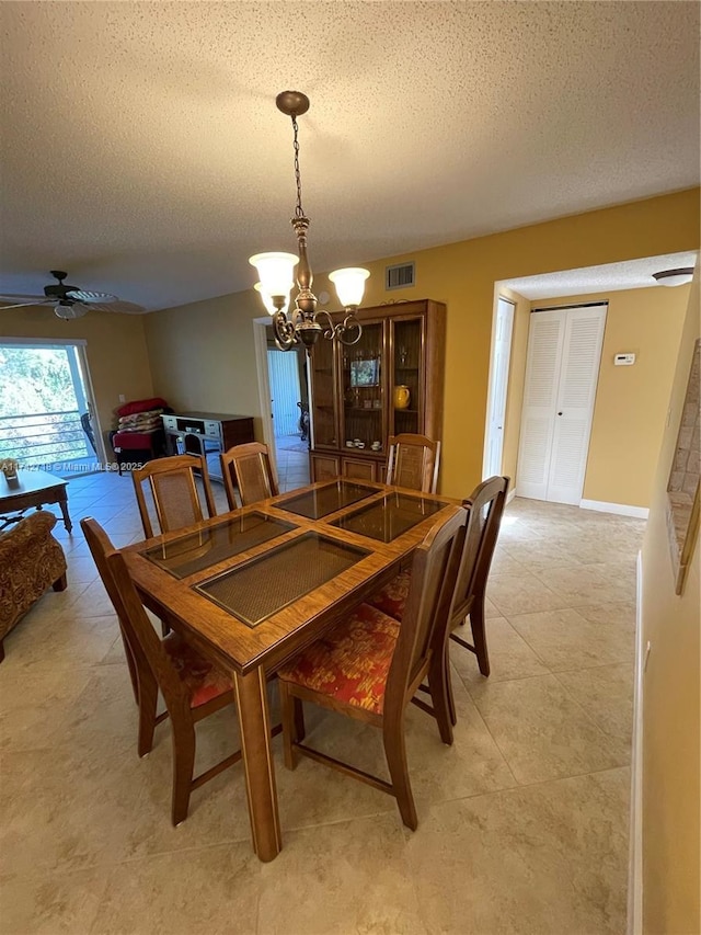 110 Lake Meryl Dr Unit 216, West Palm Beach, FL 33411 - dining space featuring a textured ceiling, visible vents, light tile patterned floors, and ceiling fan with notable chandelier