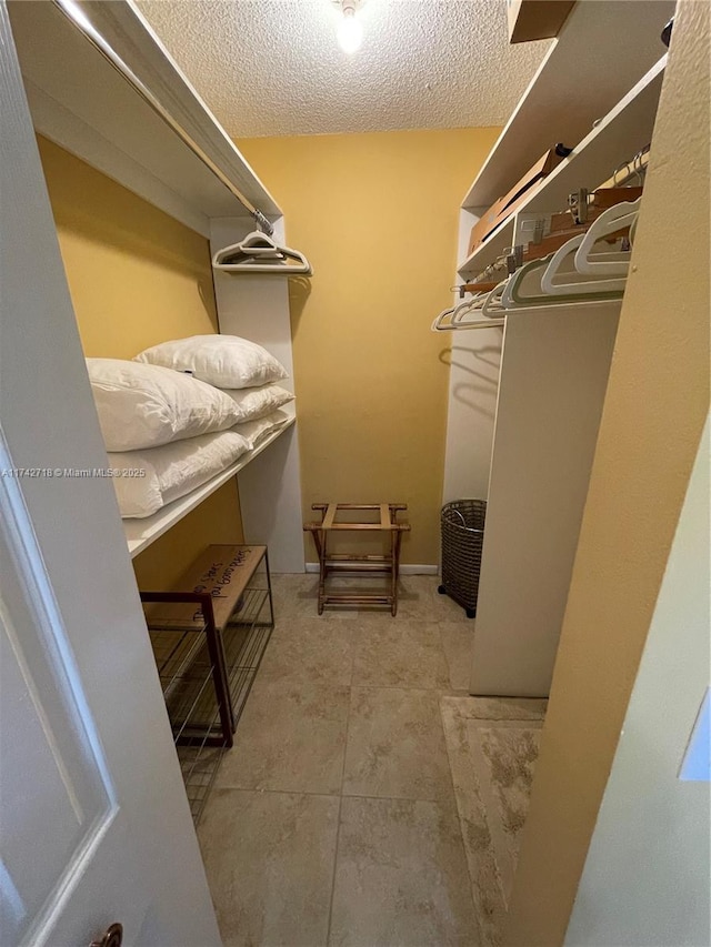 walk in closet with light tile patterned floors