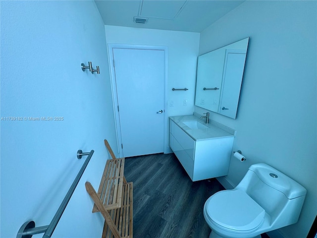 bathroom featuring vanity, wood-type flooring, and toilet