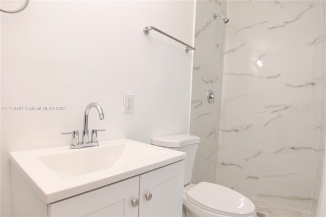 bathroom with tiled shower, vanity, and toilet