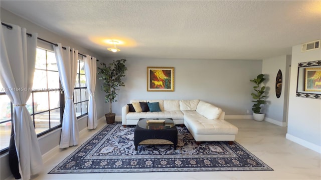 living area featuring visible vents, baseboards, and a textured ceiling