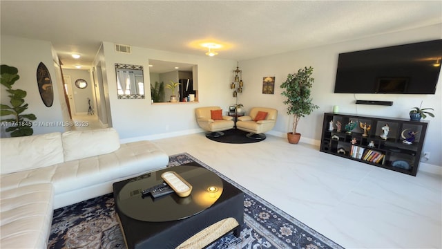 living area featuring baseboards and visible vents