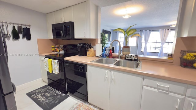 kitchen with black appliances, a sink, white cabinets, light tile patterned flooring, and light countertops